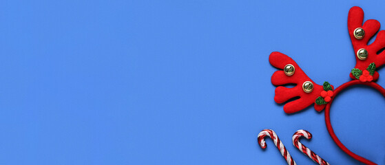 Christmas reindeer antlers headband with candy canes on blue background