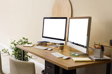 Workplace with blank computer monitors in office