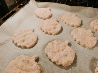 Baking homemade oat cookies on parchment paper in oven
