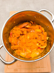 Cooking pumpkin and apple stew in stainless steel pot