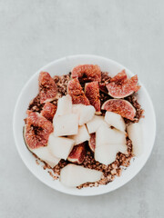 Healthy breakfast bowl with figs, pear, and granola promoting wellbeing