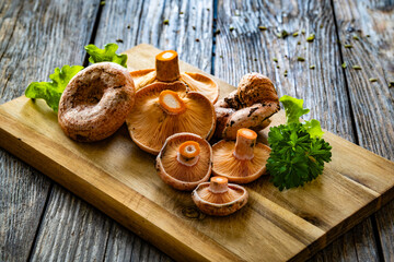 Raw saffron milk cap mushrooms on wooden table