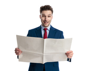 happy elegant man in navy blue suit smiling and reading newspaper