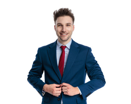 happy elegant man buttoning navy blue suit and smiling