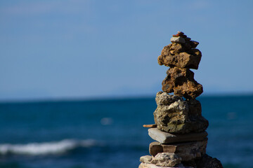 Close-Up of a Stone Cairn Stacked on the Coast with Blurred Ocean Background