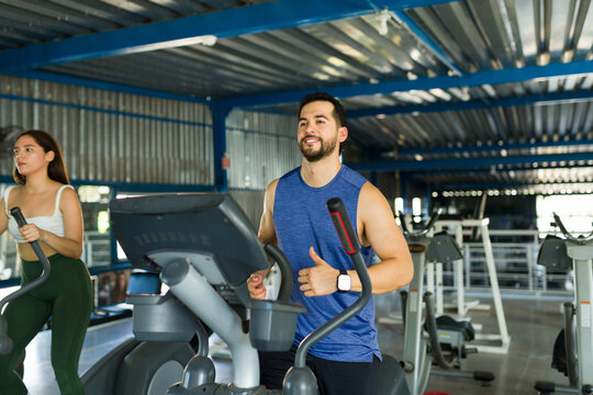 People exercising on elliptical machine at gym