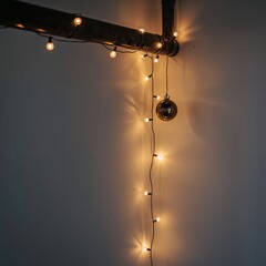 Enchanting string lights with a small mirrored disco ball draped from an industrial pipe, casting a warm and festive glow against a subtle wall