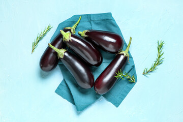 Fresh eggplants with rosemary on blue background