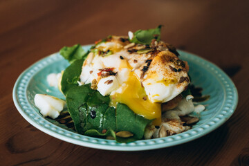 Poached eggs with spinach and seeds served on a plate  