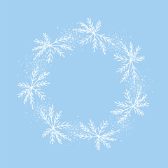 A round winter Christmas frame with hand-drawn snowflakes in doodle style. A round snowflake-shaped frame with winter holiday elements. Vector illustration on a blue background.