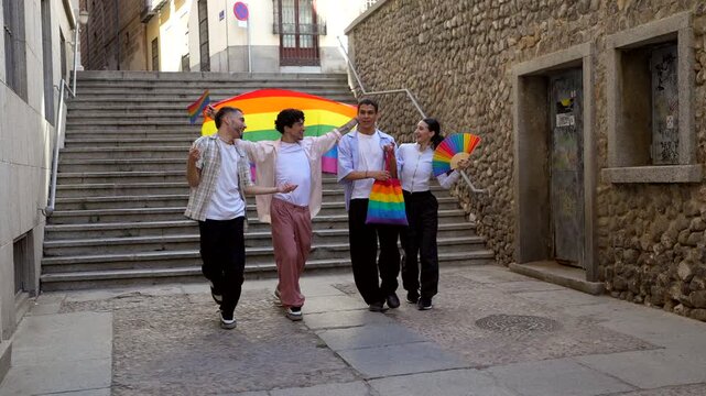Group of friends celebrating pride day walking with rainbow flags