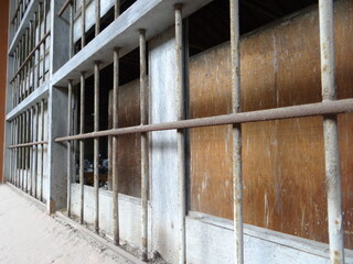 Rusty metal window bars on old building with wooden panels and industrial texture
