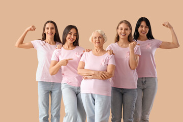 Obraz premium Group of beautiful women with pink awareness ribbons on beige background. Breast cancer concept