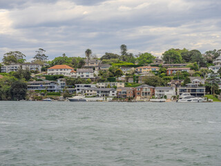 Residential Houses and apartment buildings on Parramatta River Sydney Harbour on a warm spring cloudy overcast day in Sydney NSW Australia