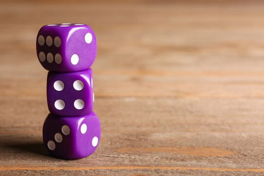 Purple dices on wooden background