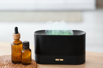 Air humidifier with essential oils on table in bathroom, closeup