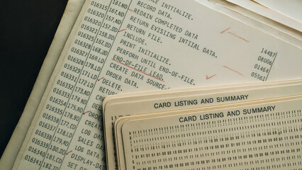 close-up vintage computer documents and punch cards. Capturing the detail of historical computing, showing the evolution of technology and data processing.