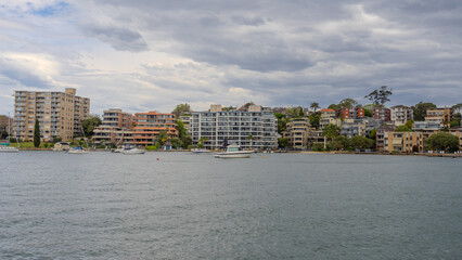 Obraz premium Residential Houses and apartment buildings on Parramatta River Sydney Harbour on a warm spring cloudy overcast day in Sydney NSW Australia