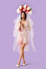 Beautiful young woman dressed as dead bride for Halloween on purple background