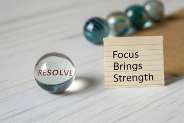 Marble ball with resolve and inspirational quote on a surface