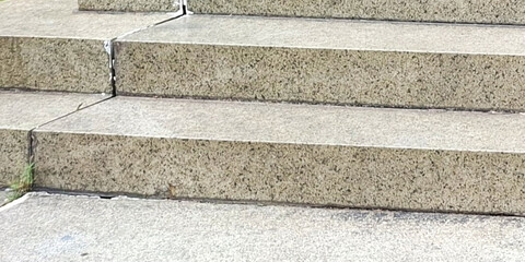 Close Up Of Rough Textured Granite Steps Leading Upwards In An Outdoor Setting