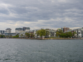 Obraz premium 11 October 2025 Residential Houses and apartment buildings on Parramatta River Sydney Harbour on a warm spring cloudy overcast day in Sydney NSW Australia