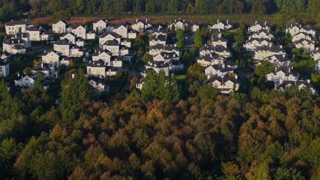 Aerial drone view of luxury home enclave in autumn landscape at sunrise