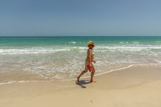 attractive senior man at the beautiful sandy beach in swim suit