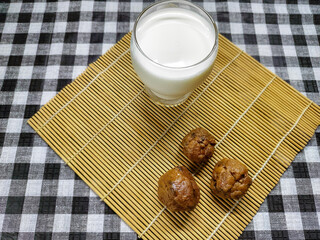 Delicious homemade chocolate ball cookies served with a refreshing glass of cold milk, an inviting sweet treat perfect for a snack or dessert at any time of day
