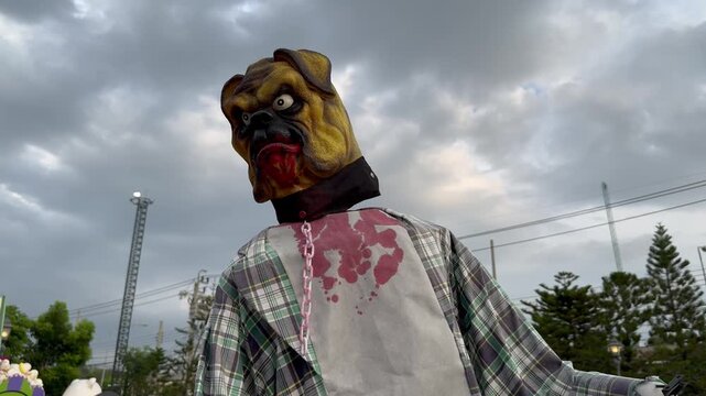 A dog-headed demon on a human body with its neck turned back and forth, is on display at an amusement park on Halloween.