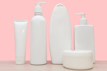 White plastic containers on a pink background. Liquid containers.