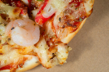 Close-up shot of seafood pizza slice with shrimp, squid, and cheese, representing authentic Italian food in macro detail.