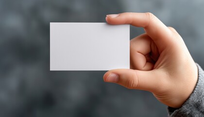Business Card Held In Hand - A Small Card Displaying Contact Information Or Business Details Being Gripped Or Held By A Person'S Hand.
