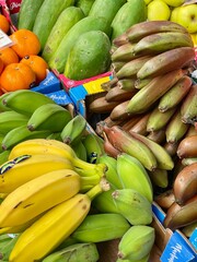 Assorted tropical fruits including various bananas and papayas on a market stall. Colorful, fresh, and organic produce for healthy eating and exotic food themes.