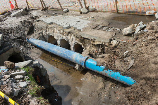 Blue water pipe exposed in excavation trench during infrastructure work in Campeche, Florian&oacute;polis - Brazil
