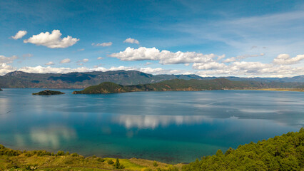 Villages by the Sunrise Lake and distant mountains, Lugu Lake in Sichuan, China
