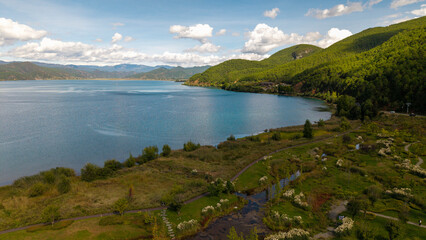 Villages by the Sunrise Lake and distant mountains, Lugu Lake in Sichuan, China