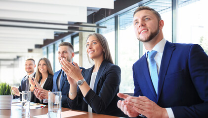 Photo of happy business people applauding at conference, focus on smiling girl