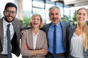 Happy modern business people expressing joyful while standing in large office