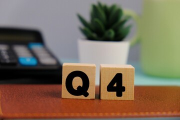 Close up of white notebook with alphabet Q4 on office desk. Fourth quarter concept.