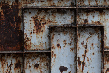 Grungy metal paneling with rust and peeling paint creates an industrial texture with weathered appeal
