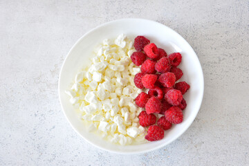 Cottage Cheese and Raspberries on a White Plate top view cut out
