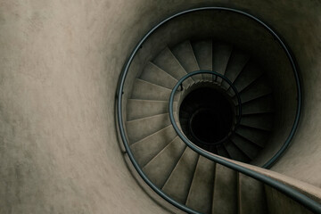 Fototapeta premium A top view of the spiral staircase leading into the darkness. Space for text.