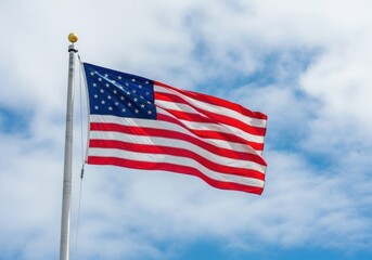 A large American flag is flying in the sky. The flag is red, white, and blue and has stars on it. The sky is clear and blue, and the flag is the only thing visible in the image