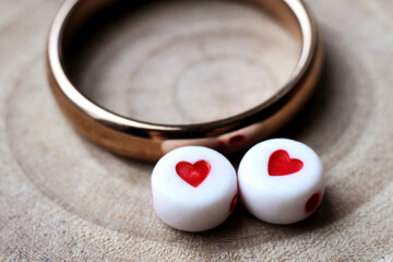 Wedding ring and two plastic hearts. Macro.