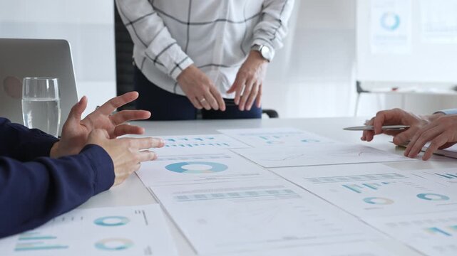 Business people team analyzing financial charts during strategy meeting, professionals discussing data and performance metrics at workplace for decision making success - Powered by Adobe