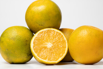 grupo de naranjas criollas agrupadas en fondo blanco, en una foto horizontal.