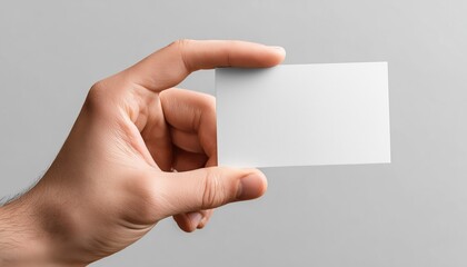 Fototapeta premium Close-Up Shot Of A Man'S Hand Holding A Blank Advertising Card Against A White Background In High Definition Quality.