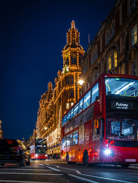 Classic red double-decker bus on festive London street at night