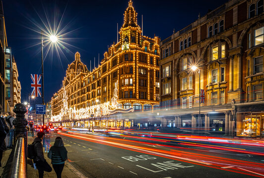 Classic red double-decker bus on festive London street at night